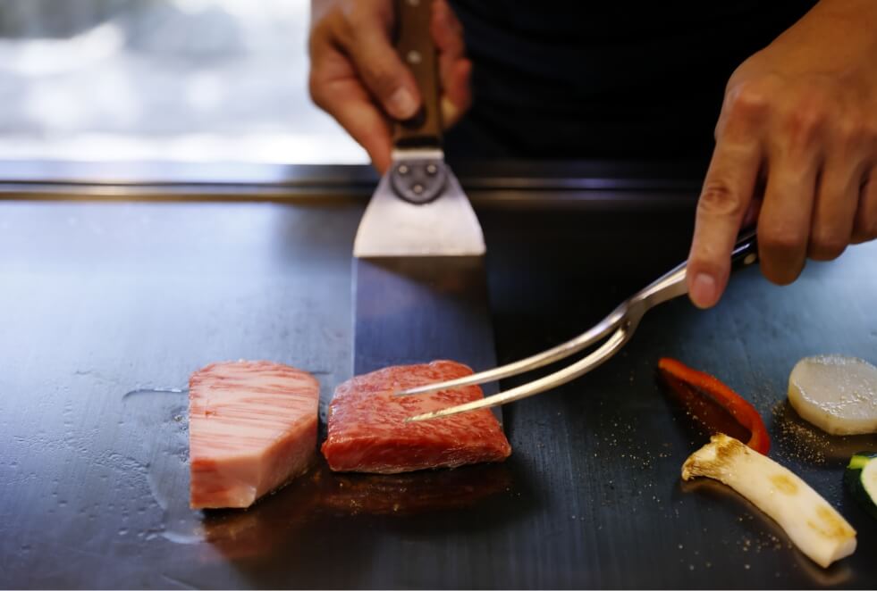 目の前の鉄板で形牛と神戸牛を焼く